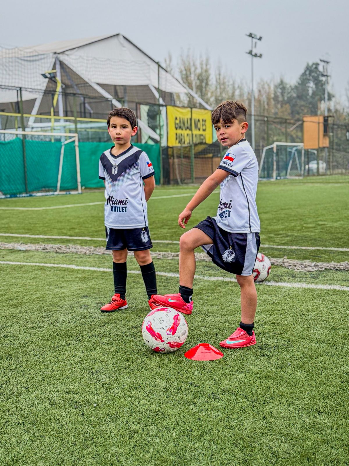 Entrenador junto a niños en una escuela de fútbol